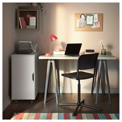 Configuración da oficina na casa: escritorio, cadeira, alfombra, lámpada, portátil.