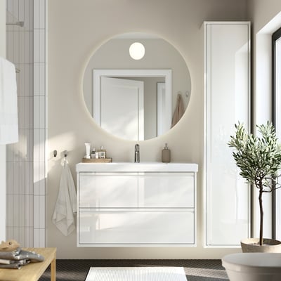 Moderna vanidade de baño branco con 2 caixóns, lavabo de cerámica e espello redondo para temática minimalista.
