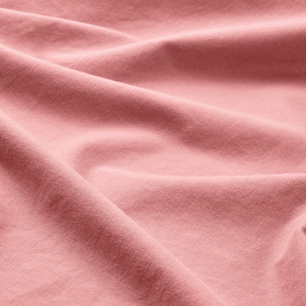 Primeiro plano dun tecido suave e rosa, que amosa a súa textura suave e delicada.