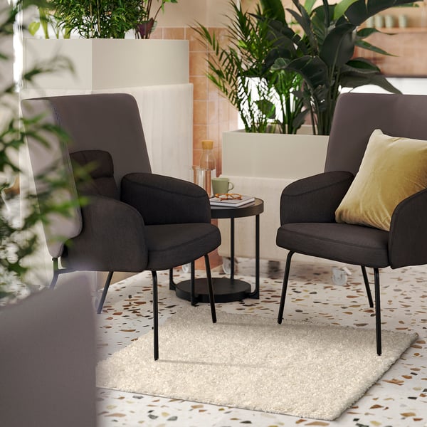 Sala de estar moderna con cadeiras ÄRENDE , mesa lateral, alfombra e plantas.