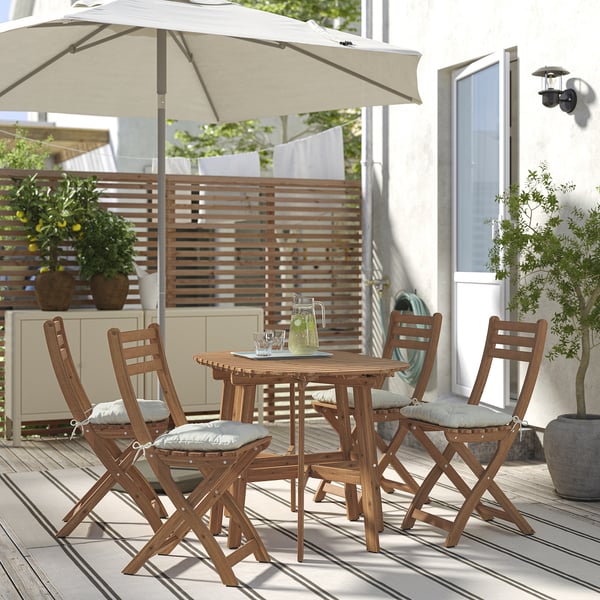 ASKHOLMEN: conxunto de patio de madeira compacto con coxíns, baixo paraugas beige, axustado a pequenos espazos.
