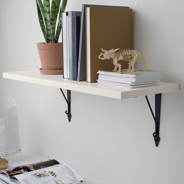 Estante de parede con libros, unha planta e un trinket decorativo. Perfecto para dormitorio ou sala de estar.