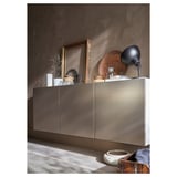 Moderno almacenamento gris con mangos elegantes e varios elementos decorativos na parte superior.