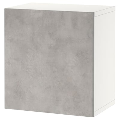 Un almacenamento branco BESTÅ cunha porta gris de efecto formigón, de forma rectangular. Ten un deseño moderno e unha superficie lisa.