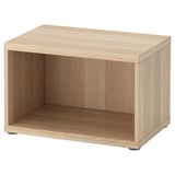 Unha unidade de almacenamento de carballo claro BESTÅ cun espazo aberto, feita de taboleiro de partículas e recheo de papel de favo de mel, cun deseño minimalista e modular.