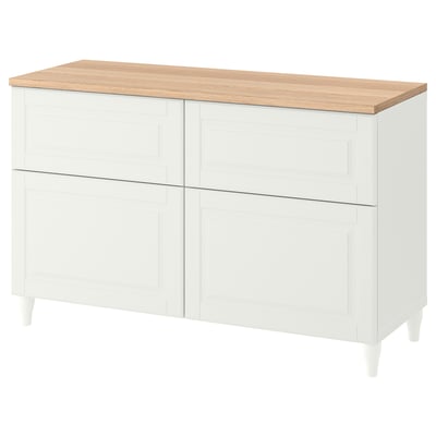 Sideboard branco BESTÅ con parte superior de carballo, patas cadradas, catro armarios, deseño minimalista.
