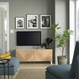 Sala de estar moderna con banco de televisión BESTÅ, plantas e decoración minimal.