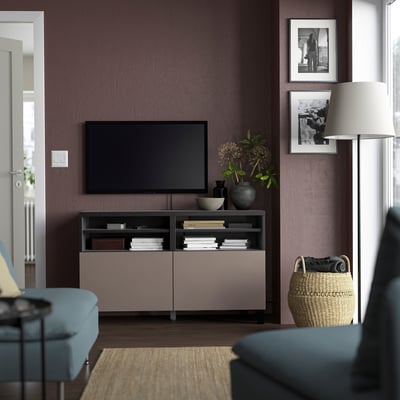 Sala de estar moderna con banco de televisión BESTÅ, televisión de pantalla plana, libros, decoración, sofá azul e lámpada