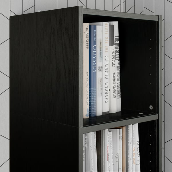 Estante de libraría negro con libros. Unidade alta con libros de varios tamaños. Deseño moderno e elegante. Adecuado para almacenamento vertical.
