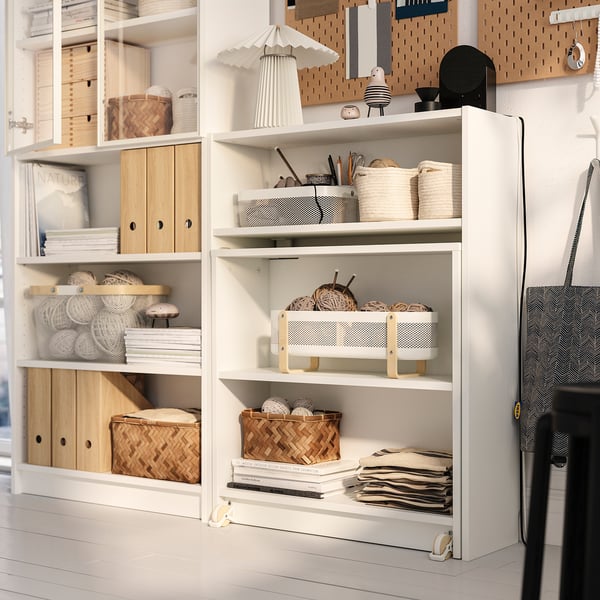 Libraría multifuncional BILLY con mesa plegable, que combina almacenamento aberto e pechado para libros, fíos e artigos.