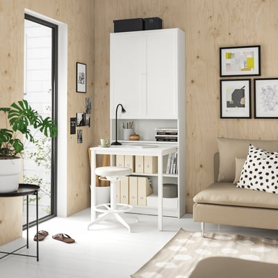 Unha oficina na casa moderna con escritorio branco BILLY, sofá beige e arte da parede.