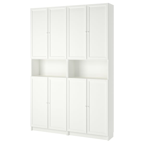 Unha libraría branca BILLY con estantes axustables e portas de armarios. Ten un deseño tradicional cunha forma cadrada e superficies limpas e planas.