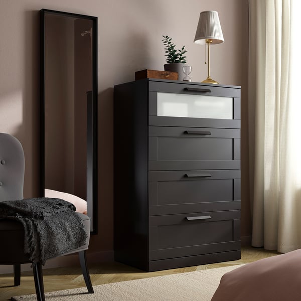 Dormitorio moderno con peito BRIMNES gris escuro con parte superior de vidro xeado. Deseño alto e elegante con catro caixóns xunto a un espello de lonxitude completa e cama.
