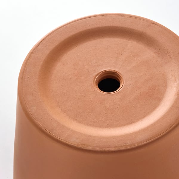 Primeiro plano de vasos de terracota superficie lisa e robusta e burato de drenaxe.
