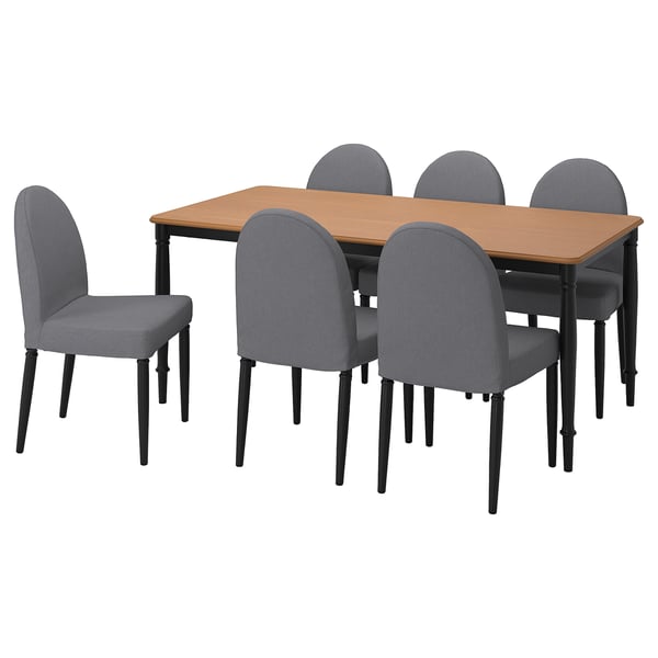 Cinco cadeiras acolchadas grises con pernas negras rodean unha mesa cadrada de madeira clara. Comedor moderno e práctico.