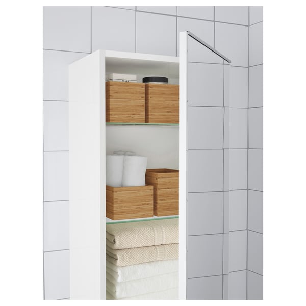 Baño moderno con baldosas brancas, almacenamento de madeira, luces de espello, toallas organizadas.