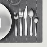 Cubertas de aceiro inoxidable en placemat gris.
