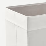 Primeiro plano de caixa de almacenamento de tecido branco con costuras robustas e parte superior de malla, mostrando un deseño de calidade.