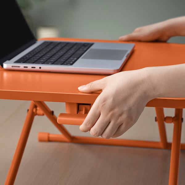 Axustar o soporte portátil laranxa DUBBLA no escritorio, suxeitando o portátil para traballos ergonómicos.