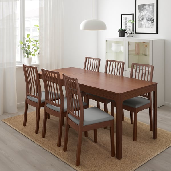 Conxunto de comedor EKEDALEN con mesa extensible e catro cadeiras de brazos, coxíns marróns cálidos e grises, comedor minimalista.