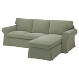 Sofá verde con chaise anexo, deseño de brazos enrolados, cuberta de tecido suave.