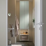 Baño moderno con almacenamento ENHET, espello, paredes beige e toallas colgantes.