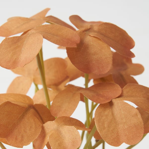 Flores artificiais con pétalos laranxas e talos verdes dispostos estreitamente xuntos.