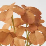 Flores artificiais con pétalos laranxas e talos verdes dispostos estreitamente xuntos.