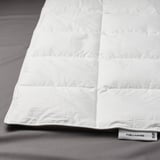 Primeiro plano de duvet branco de fjällräven na cama con patrín cosido en caixa e etiqueta FJÄLLHAVRE.