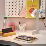 Escritorio con lámpada FLOTTILJ, cunca vermella e caderno. Elegante e eficiente.