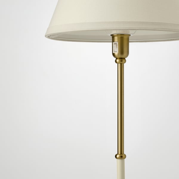 Lámpada elegante con sombra crema e base metálica dourada, robusta e elegante.