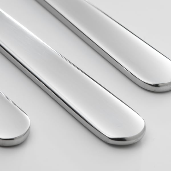 Primeiro plano de coitelos elegantes e pulidos, que reflecten a luz, feitos de aceiro inoxidable brillante.