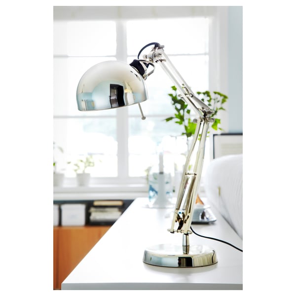 Unha lámpada de escritorio de aceiro elegante e axustable, inclinada para proporcionar luz direccional.
