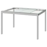 Mesa de vidro GLIVARP: elegante, rectangular, con marco cromado e tapa de vidro transparente. Deseño moderno e minimalista para pequenos espazos.
