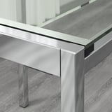 Mesa moderna de cristal con pernas metálicas, deseño pulido e elegante.