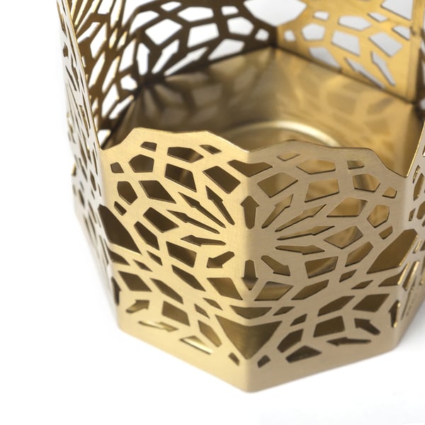 Soporte octogonal de metal dourado con intrincados recortes florais. Deseño elegante e festivo para un ambiente cálido e invitante.