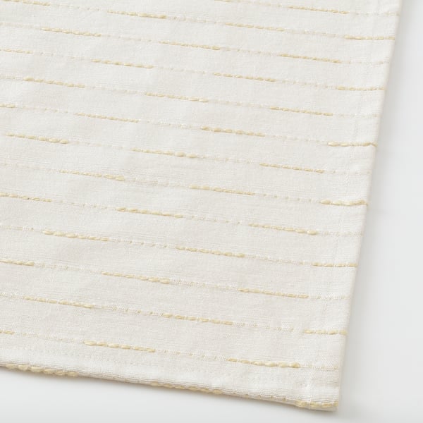 Primeiro plano de alfombra tecida beige, mostrando textura de calidade e superficie plana hixiénica.