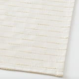 Primeiro plano de alfombra tecida beige, mostrando textura de calidade e superficie plana hixiénica.