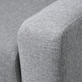 Primeiro plano dun recuncho de sofás modernos, mostrando tecido gris suave e peluche con costura limpa.