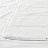 Primeiro plano de duvet branco liso con sutís costuras, mostrando tecido de alta calidade.