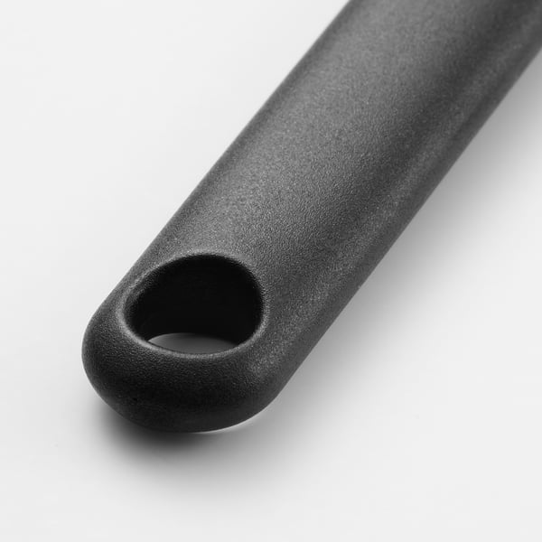 O mango do cepillo de grella de silicona negra, texturizado para o agarre, cun burato para colgar.