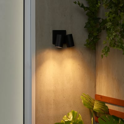 Lámpada de parede negra con 2 lámpadas, plantas verdes, engade luz acolledora.