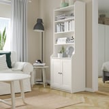 Sala de estar moderna con estante de libros HAUGA, sofá, mesa de café e lámpada.