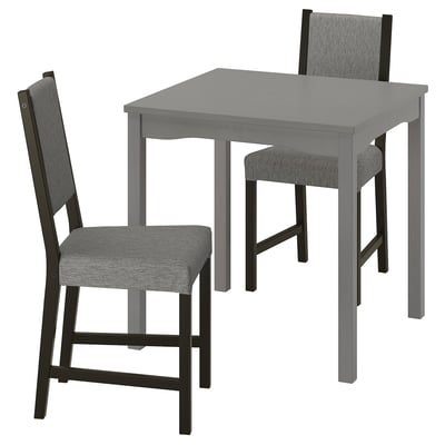 Un comedor compacto e moderno cunha mesa gris e cadeiras almofadadas correspondentes, ideal para espazos pequenos.