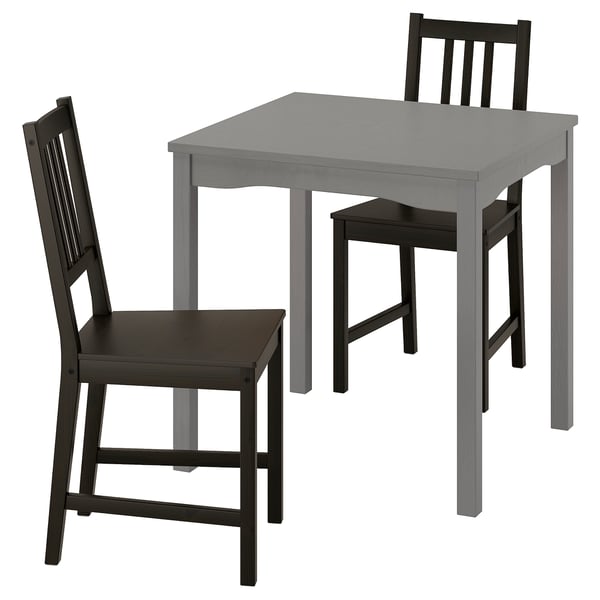 Comedor moderno con mesa gris e cadeiras negras.