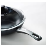 Wok de alta calidade cunha tapa de vidro transparente e un mango robusto, deseñado para unha distribución uniforme da calor e un fácil manexo.