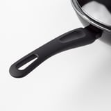 Un primeiro plano dun robusto mango negro woks, destacando o seu cómodo agarre e o seu deseño duradeiro.