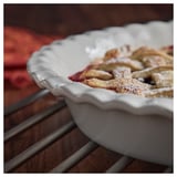 Torta de mazá en prato de gres, cortiza dourada, espolvoreada con azucre.