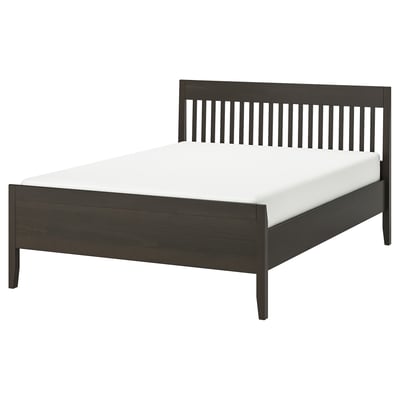 Unha elegante e moderna cama IDANÄS en madeira marrón escuro cunha cabeceira e un pé, soportando un colchón branco.