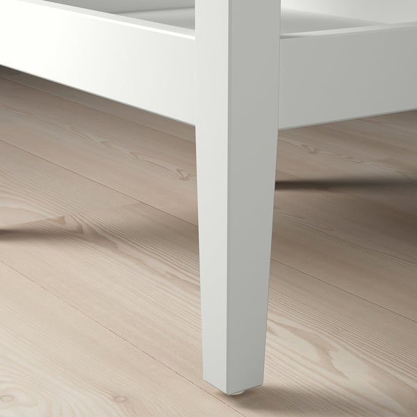 Moderna perna de mesa de madeira branca sobre chan de madeira lixeira, mostrando un deseño elegante e unha construción robusta.